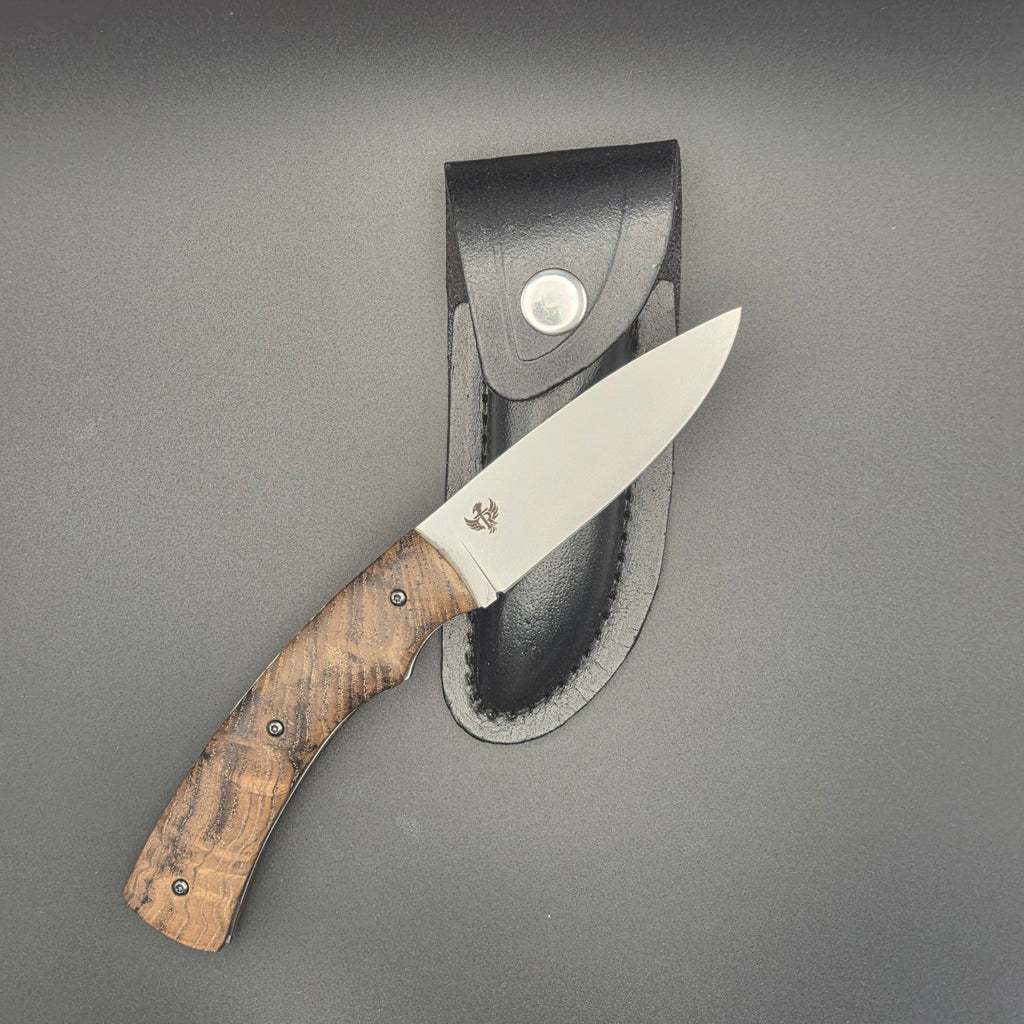 Etui de couteau noir sur lequel se trouve un couteau pliant fabriqué par tony raone