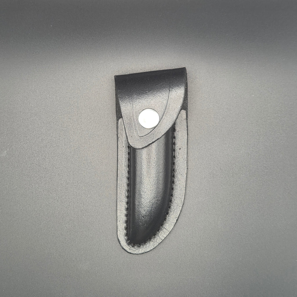 etui noir en croute de cuir posé et en position fermé pouvant accueillir un couteau pliant de 12cm environs
