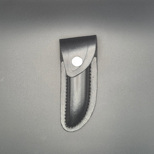 etui noir en croute de cuir posé et en position fermé pouvant accueillir un couteau pliant de 12cm environs