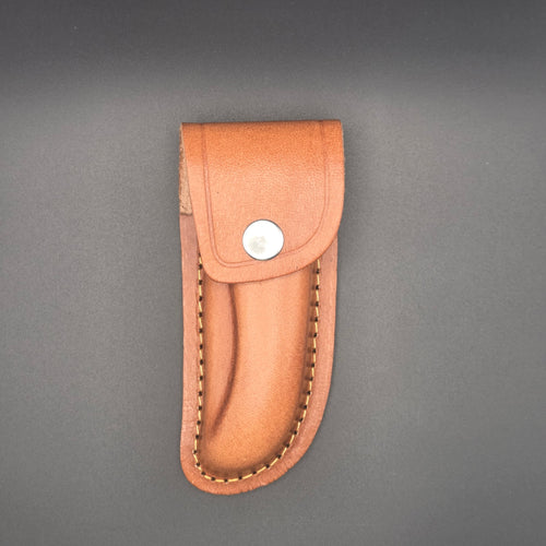 etui de couteau marron en croute de cuir. Il est vu de face et il est fermé