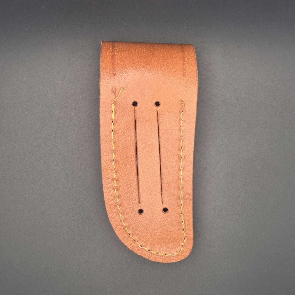 vue arrière d'un étui marron pour couteau en croute de cuir. on voit des rainures permettant de le mettre à la ceinture