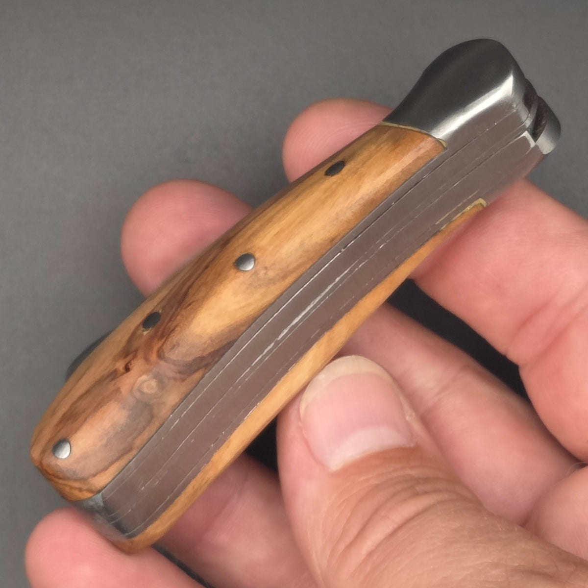 couteau pliant serpette et greffoir en position fermé tenu dans une manche. Manche en teck et qualité de second choix