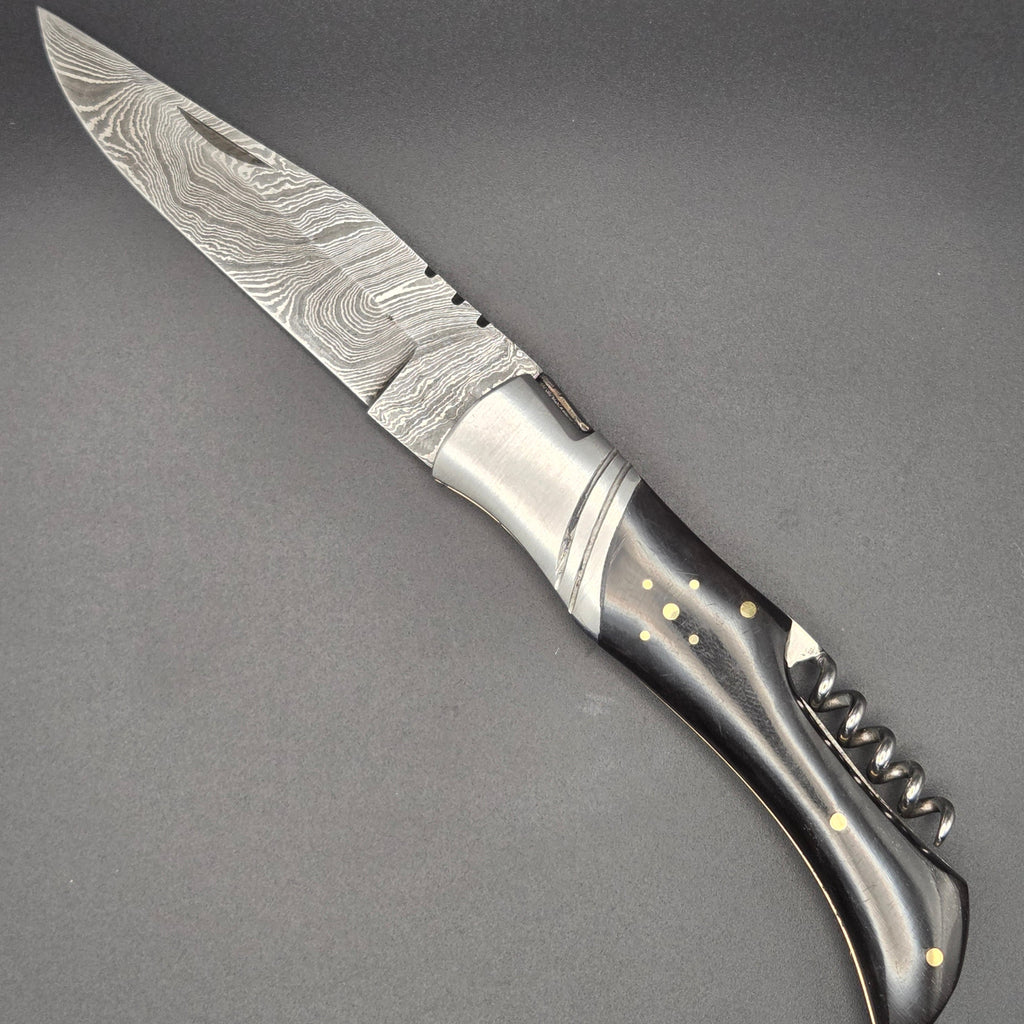 couteau pliant utilitaire muni d'un tire-bouchon et équipé d'une lame en damas.