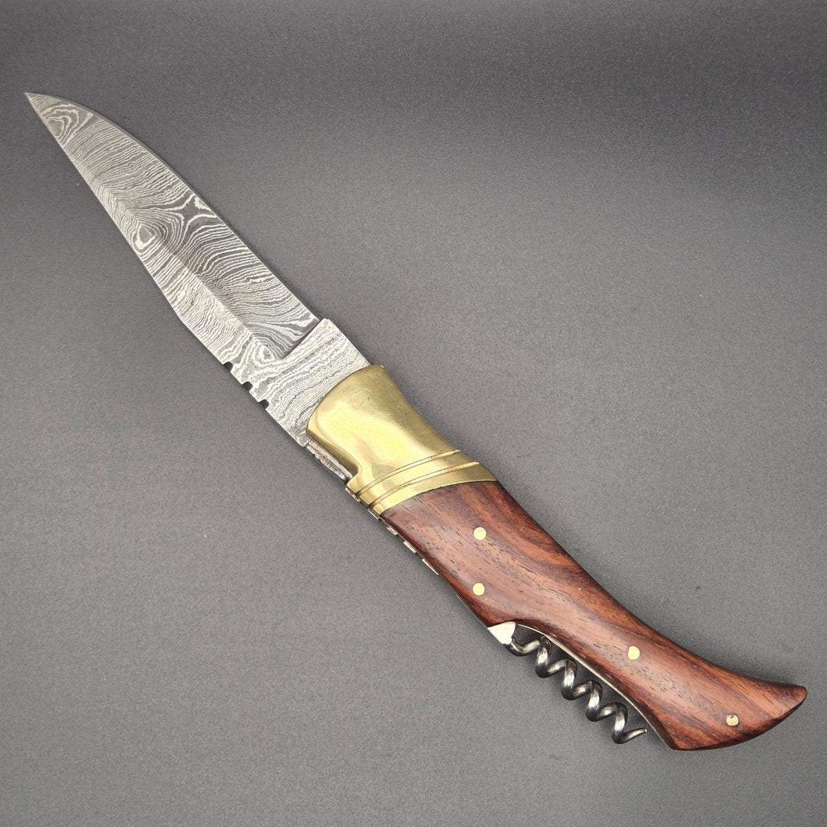 vue latérale d'un couteau utilitaire pliant muni d'une lame en damas et d'un tire-bouchon qui est en position ouverte.