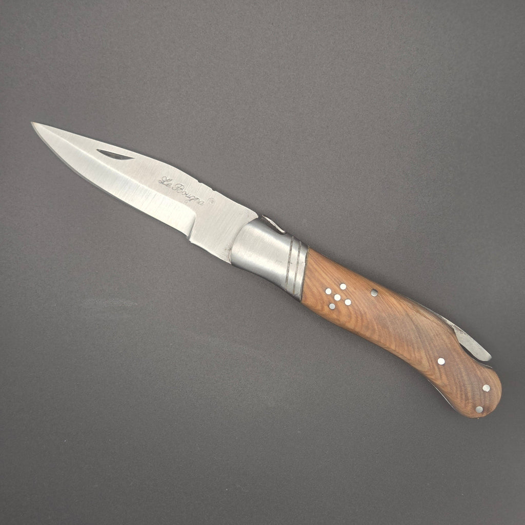 couteau utilitaire pliant posé à plat en position ouvert. On y voit une inscription La Bougna sur la lame et le manche est en teck. Couteau de second choix niveau qualité
