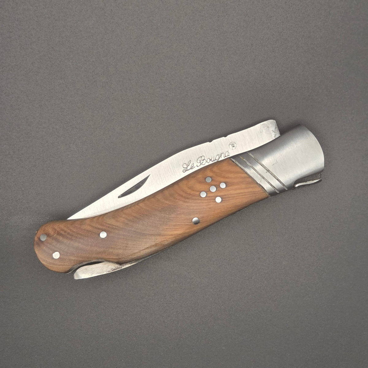 couteau pliant utilitaire posé à plat en position fermé. On y voit l'inscription La Bougna sur la lame et le manche en teck.