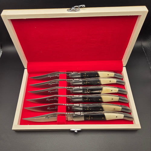 coffret en bois ouvert montrant 6 couteaux de table en inox avec un manche en corne et os.