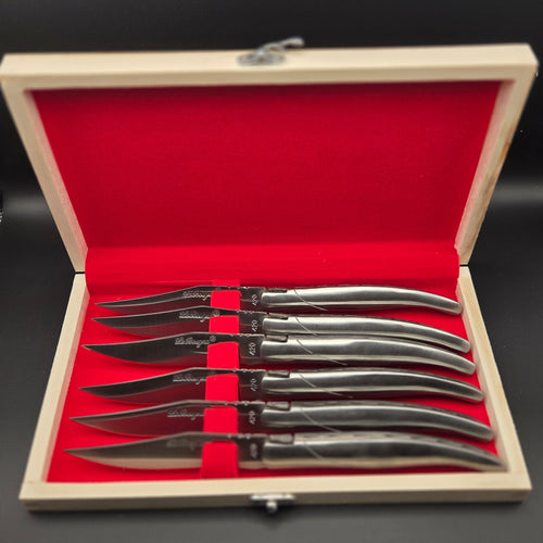 Coffret en bois ouvert où on voit l6 couteaux de table La Bougna bien rangé dedans. Ils ont un manche en inox.