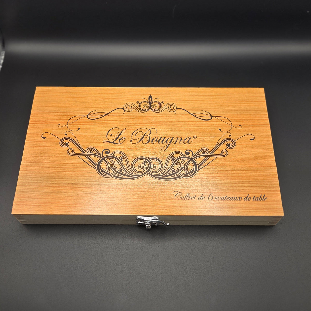 Coffret contenant 6 couteaux de table La Bougna munis d'un manche en teck. Le coffret est fermé.