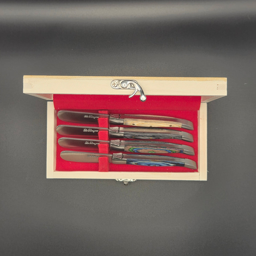vue de haut d'un coffret en bois comportant 4 couteaux à beurre différents