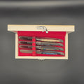 vue de haut d'un coffret en bois comportant 4 couteaux à beurre différents