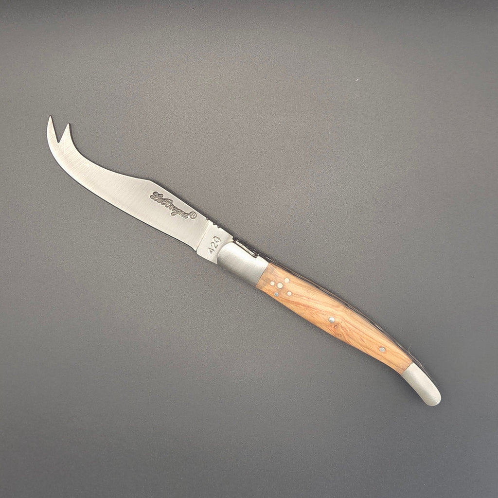 Couteau à fromage posé à plat on y voit sa lame spécifique gravée des mots La Bougna. Il possède un manche en teck