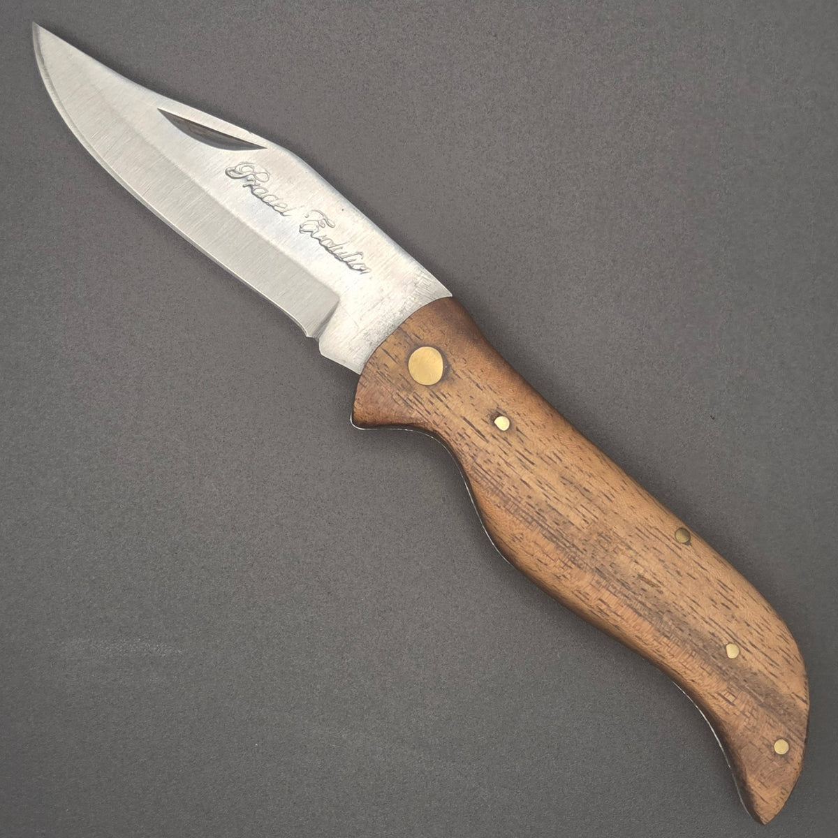 Couteau pliant utilitaire berge posé à plat en position ouvert