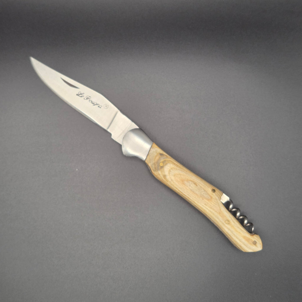 Couteau utilitaire pliant avec son manche en teck blanchi et son tire-bouchon posé à plat et en position ouvert.