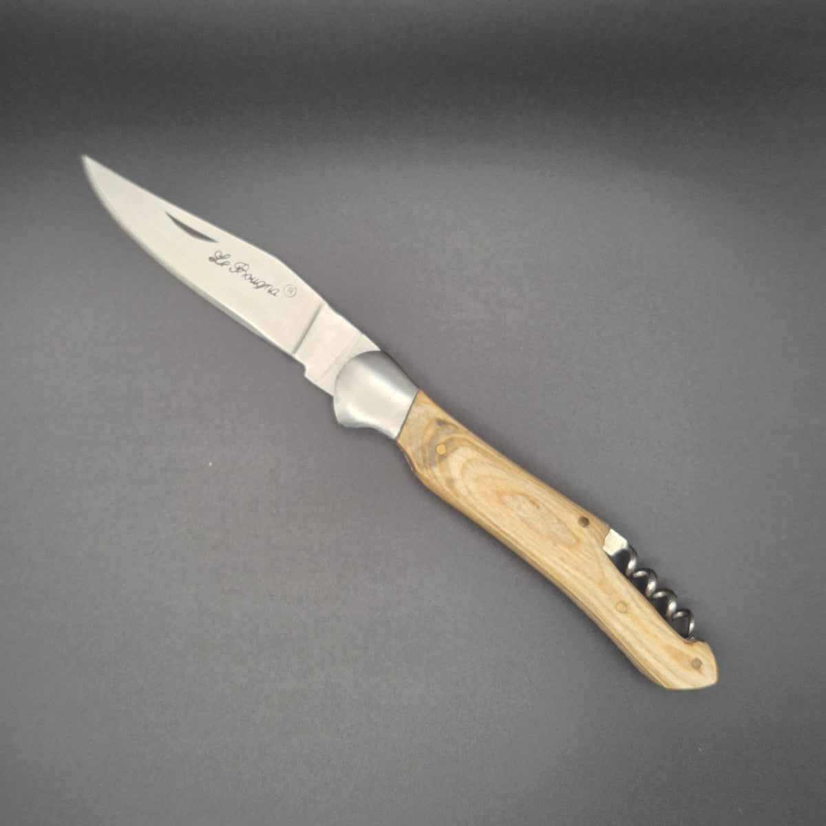 Couteau utilitaire pliant avec son manche en teck blanchi et son tire-bouchon posé à plat et en position ouvert.