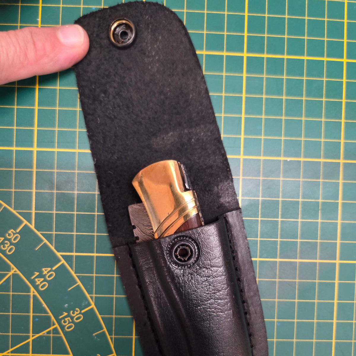 vue de haut d'un étui pour couteau pliant il est ouvert et on peut apercevoir un couteau pliant rangé dedans